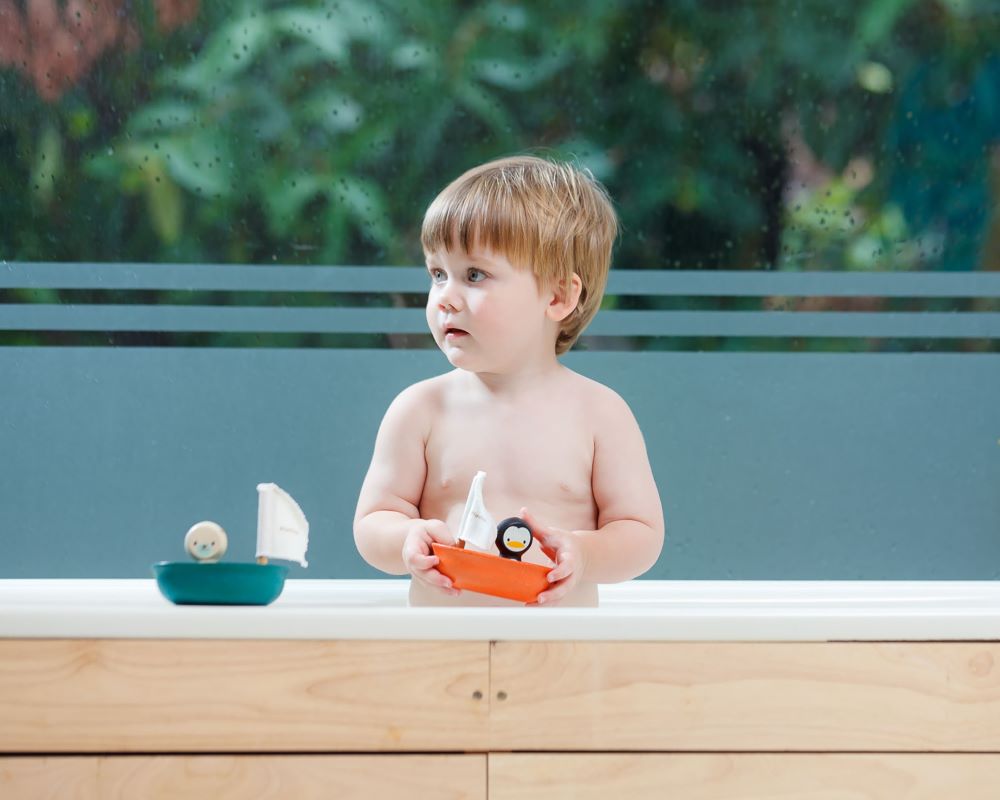PlanToys Penguin Sailing Boat Bath toy with child in the bath