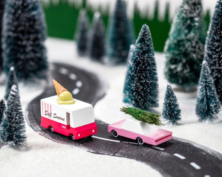 A CandyCar and CandyVan driving through snowy forest scenery