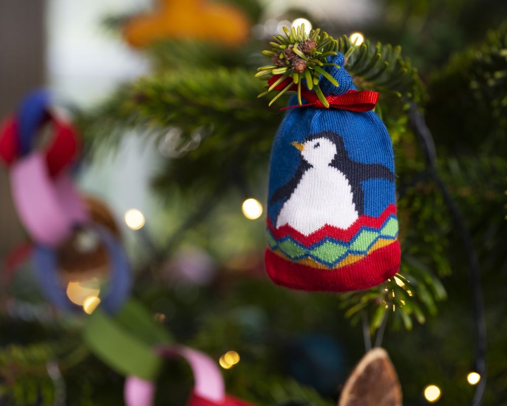 Frugi Penguin super socks in a bag, organic cotton socks for toddlers hanging on a Christmas tree.