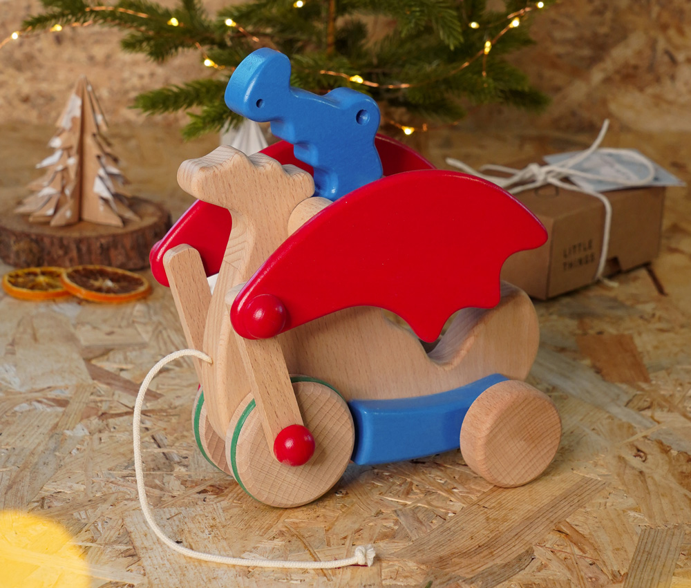 Bajo wooden sustainable toys, Pull along Dragon in blue, with Christmassy backdrop.