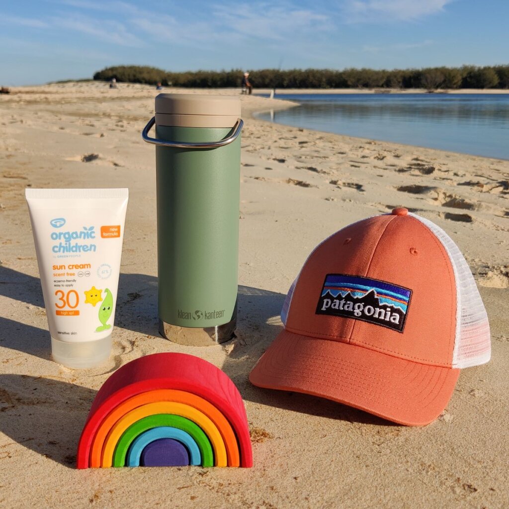 Babipur beach essentials - Patagonia cap, Klean Kanteen, Green People Organic Children suncream and a Grimm's rainbow.