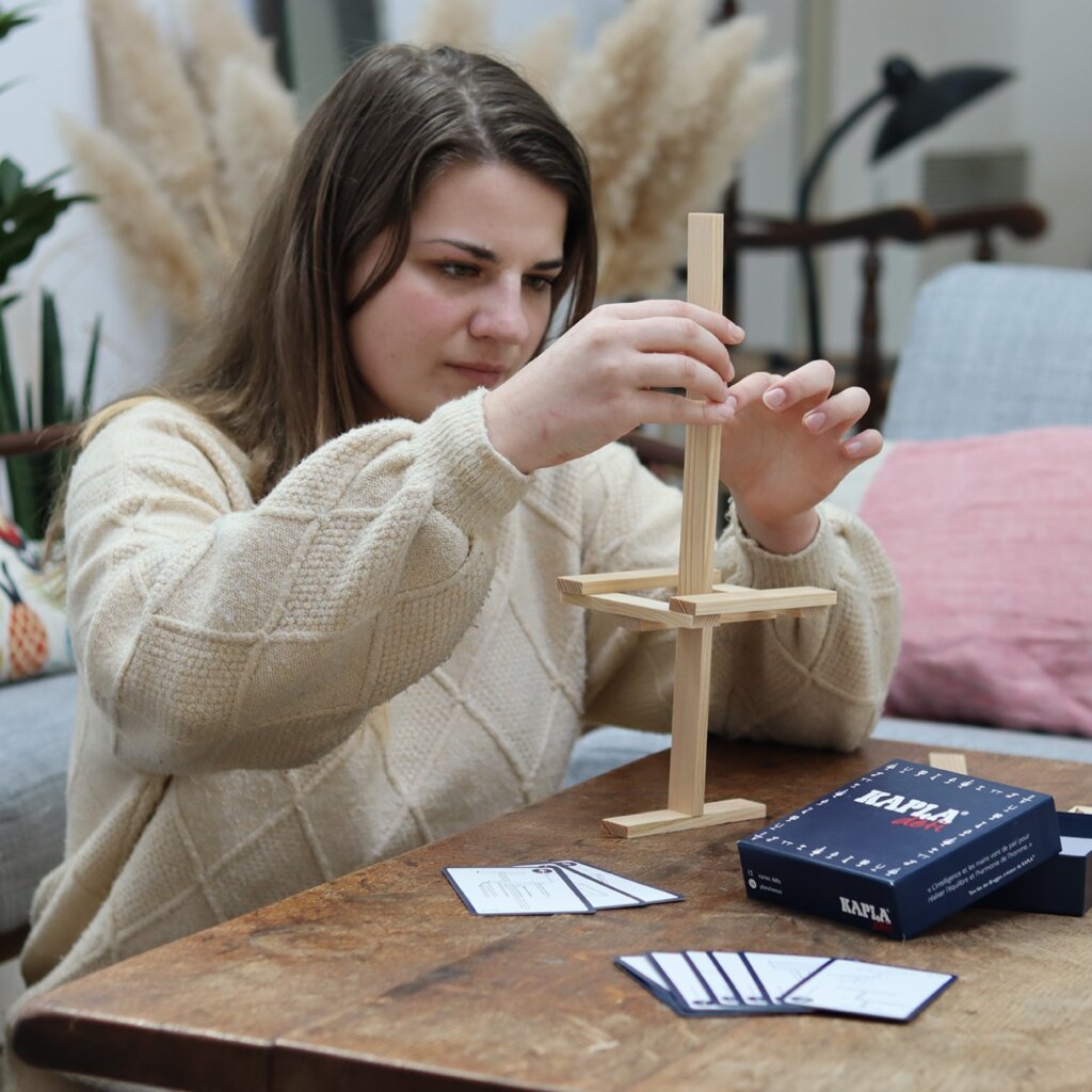 Woman playing the Kapla challenge at a table