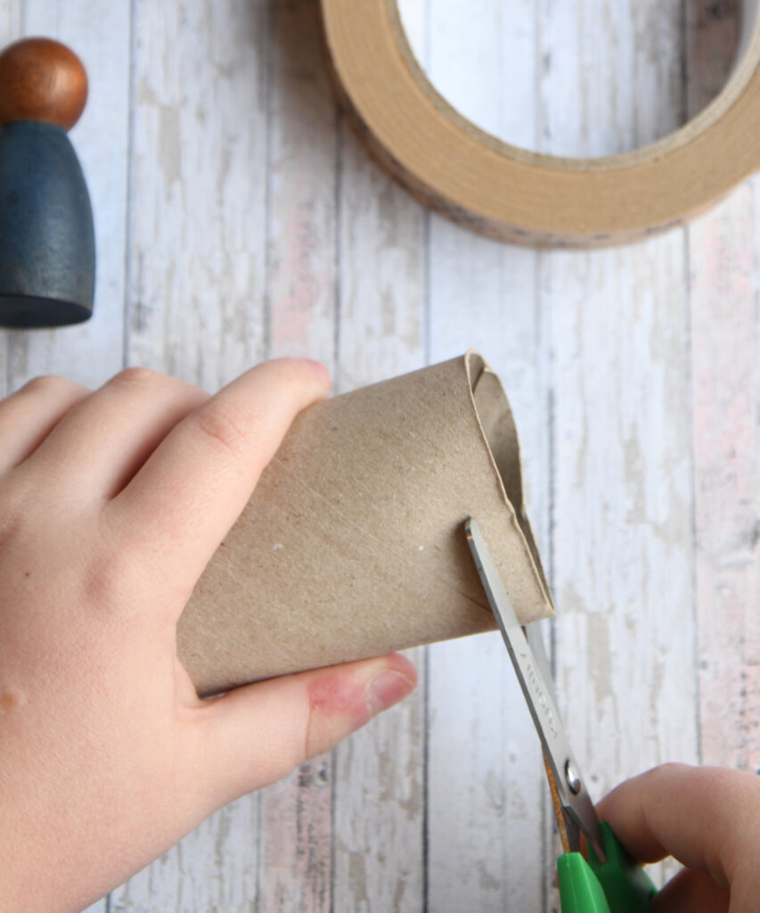 Start by cutting a cardboard tube to a thickness of about 1cm. Adjust the size to fit the head of your peg doll. Secure the ends together with paper craft tape to form a crown.
