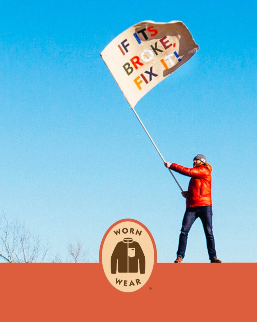 Person waving a flag saying 'If its broke, fix it' as part of Patagonia's Worn Wear campaign